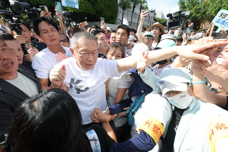 柯文哲涉及京華城等案聲請具保停押,獲裁定以7千萬元交保;柯文哲(前白衣者)8日下午步出台北地方法院,在支持者簇擁下走向座車,準備回新竹探望母親。中央社