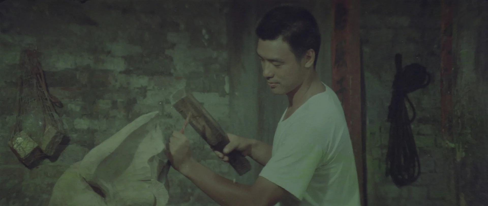 主角陳文雄拿著刻刀一筆一劃地雕刻木頭，畫面外的修復組同仁，同時也一筆一劃，修復畫面細節。國家影視聽中心提供