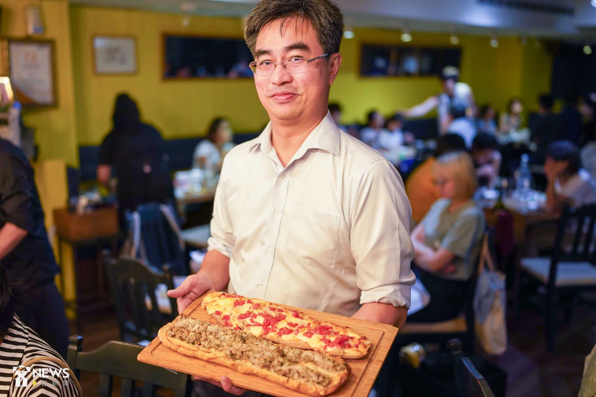 超級桌邊服務生徐仲端著烤好的覆菜肉丸怒吃餅。李台源攝