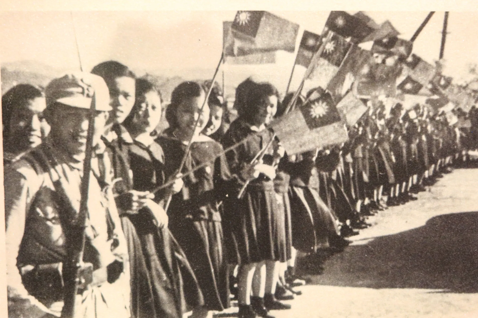 1945年第二次世界大戰結束，台灣光復，青年學子手持國旗歡迎來台接收的國軍。何來美翻攝自台北二二八紀念館