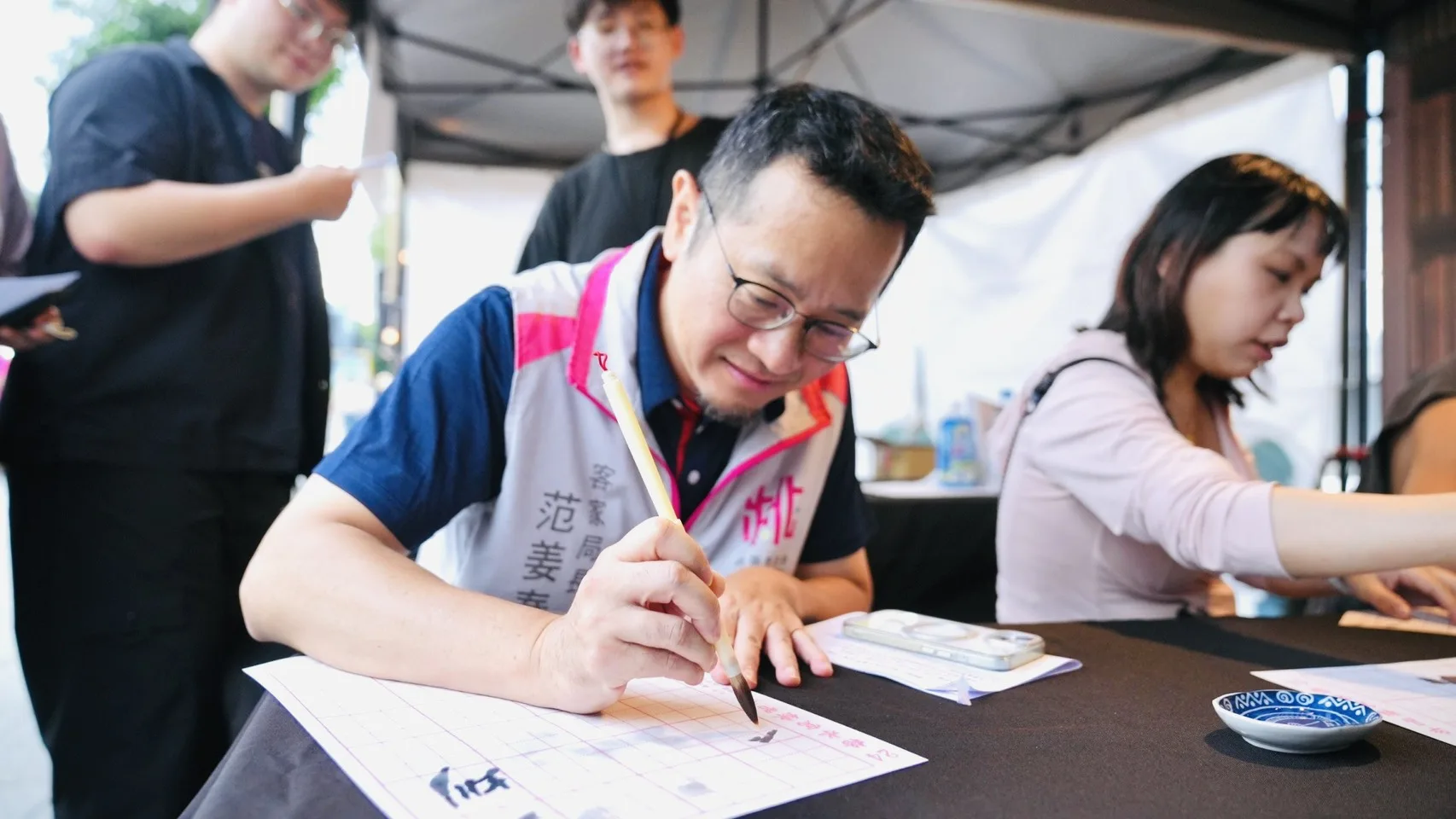 客家局長范姜泰基現場體驗書法活動,揮毫感受傳統文化魅力。桃園市政府提供