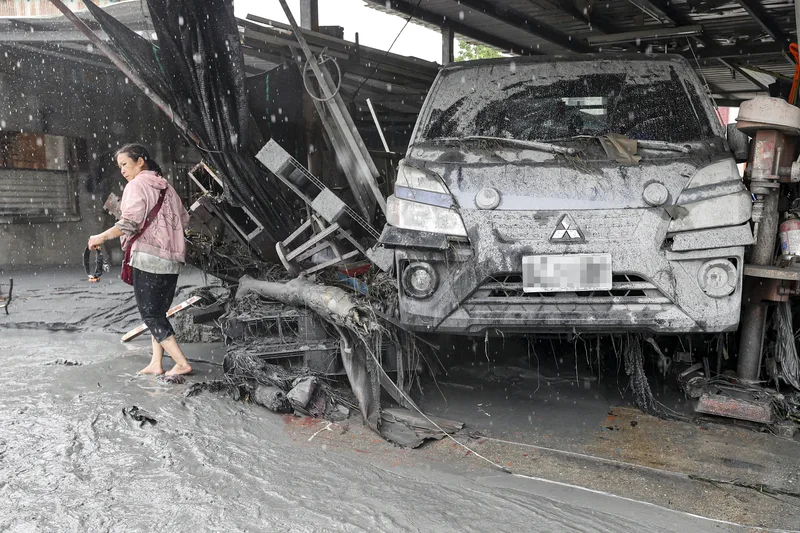 花蓮馬太鞍溪堰塞湖23日下午溢流造成光復鄉淹水災情，圖為24日陣雨不斷，民眾赤腳在泥水中展開清理。中央社