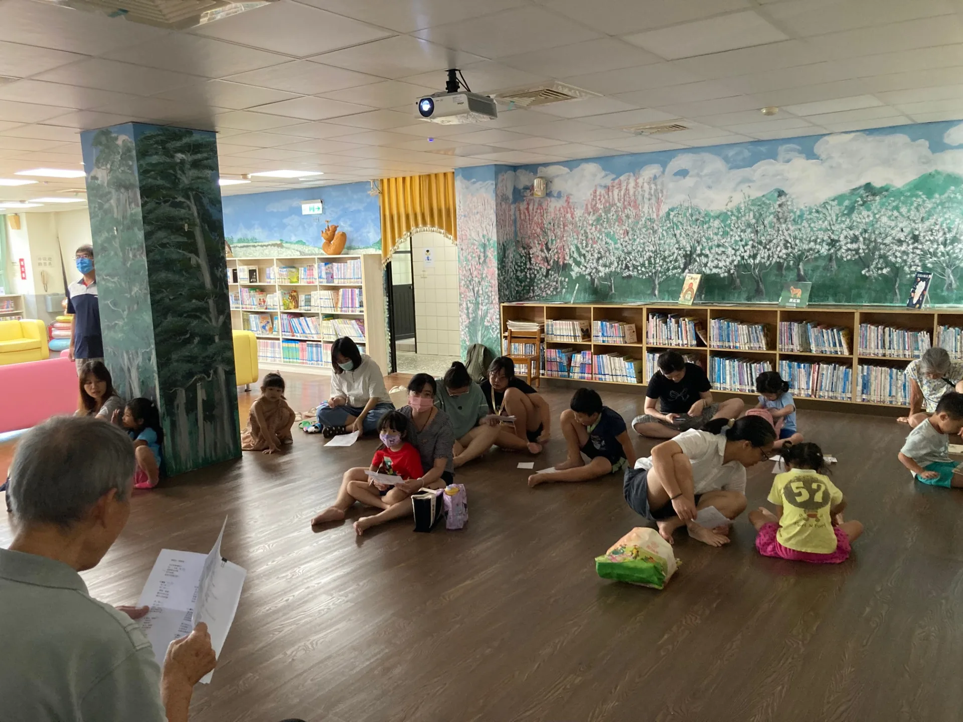 家長在旁引導孩子跟讀客語童謠，增進語言沉浸與親子互動。