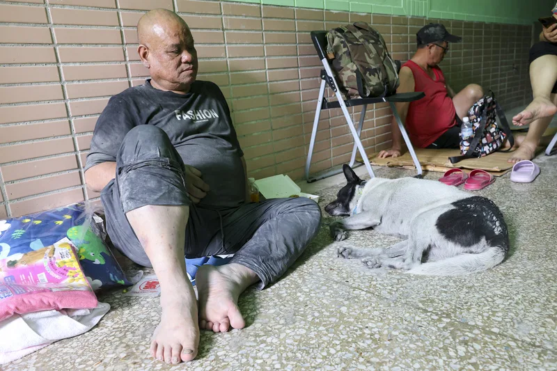 花蓮馬太鞍溪堰塞湖溢流,造成光復鄉嚴重災情,目前仍有上百人失聯。圖為24日大進國小收容中心災民與狗狗。中央社