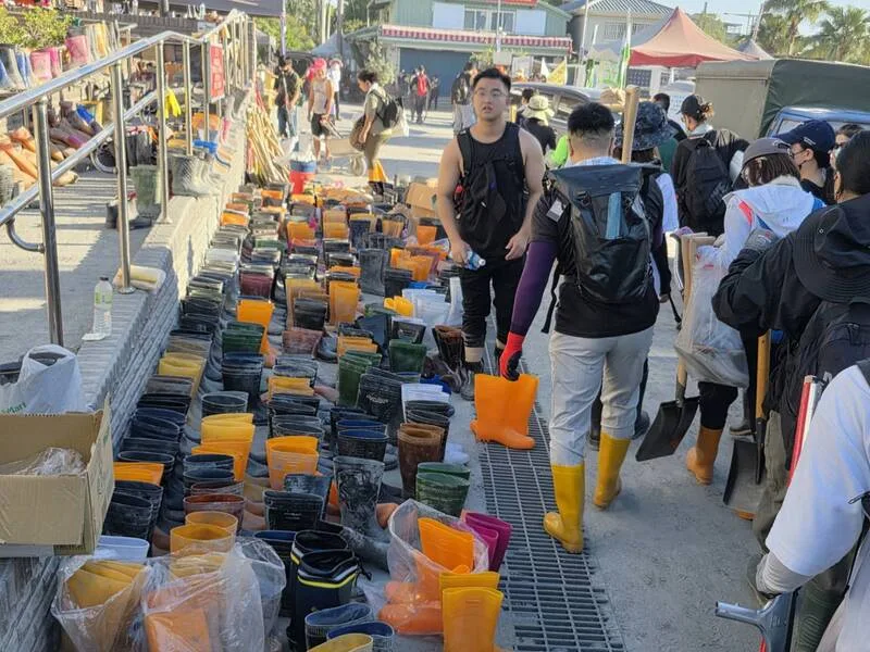 各地「鏟子超人」離開前,將雨鞋、鏟子等清理工具整齊排放在光復車站前,讓下一批超人接手使用。中央社