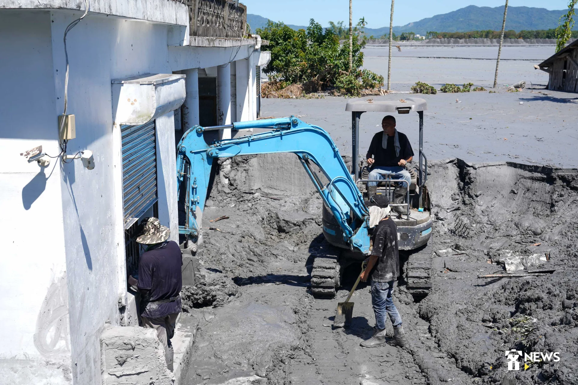 胡國勇指揮、胡閏元開怪手，與眾人分工合作清出一條道路。李台源攝