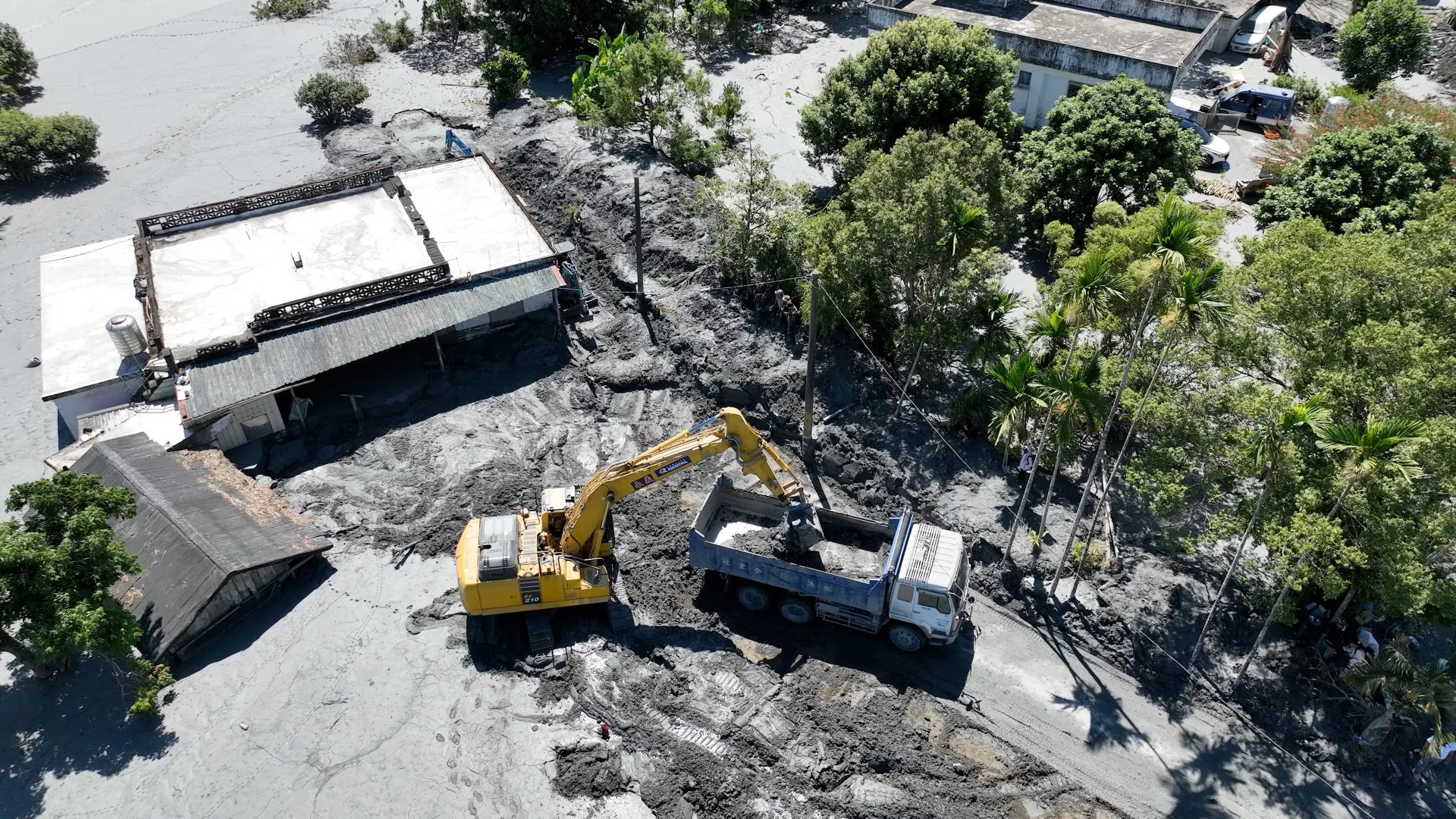 怪手鏟起淤泥，卡車將淤泥載往臨時堆置場。范修語攝