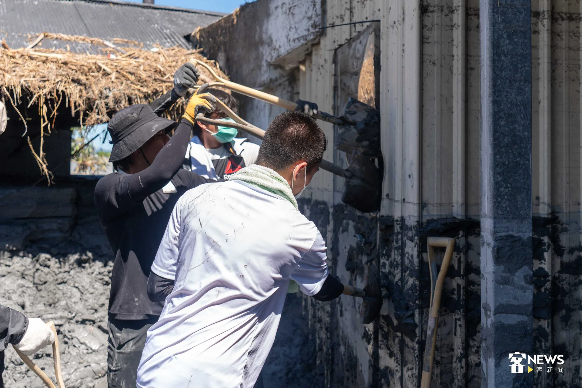 志工合力開啟房屋後門。范修語攝