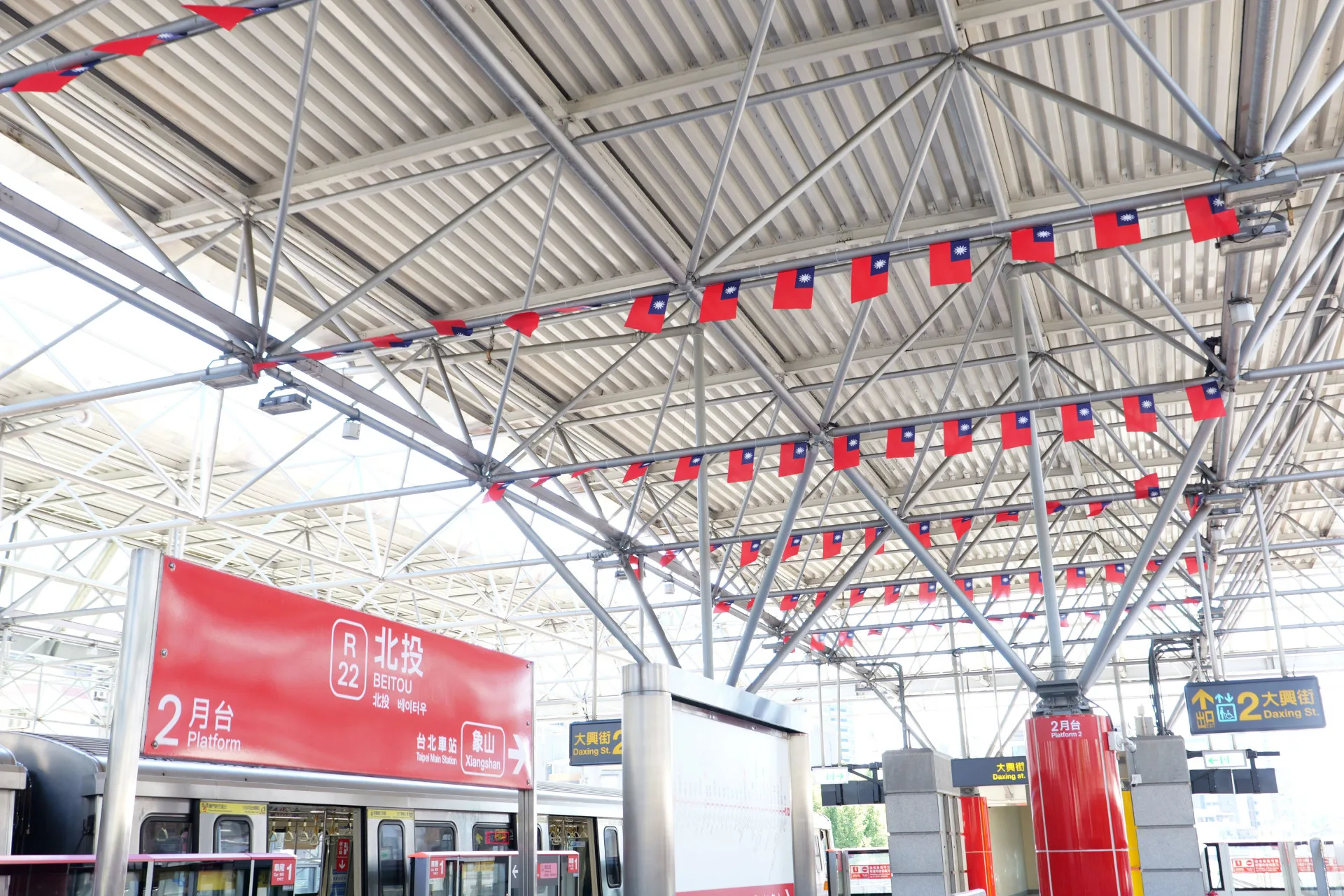 北投站更特別將國旗設置於半戶外月臺上方，陽光灑落、旗幟隨風飄動，與天空相映成趣，成為最動人的國慶風景。臺北大眾捷運股份有限公司提供