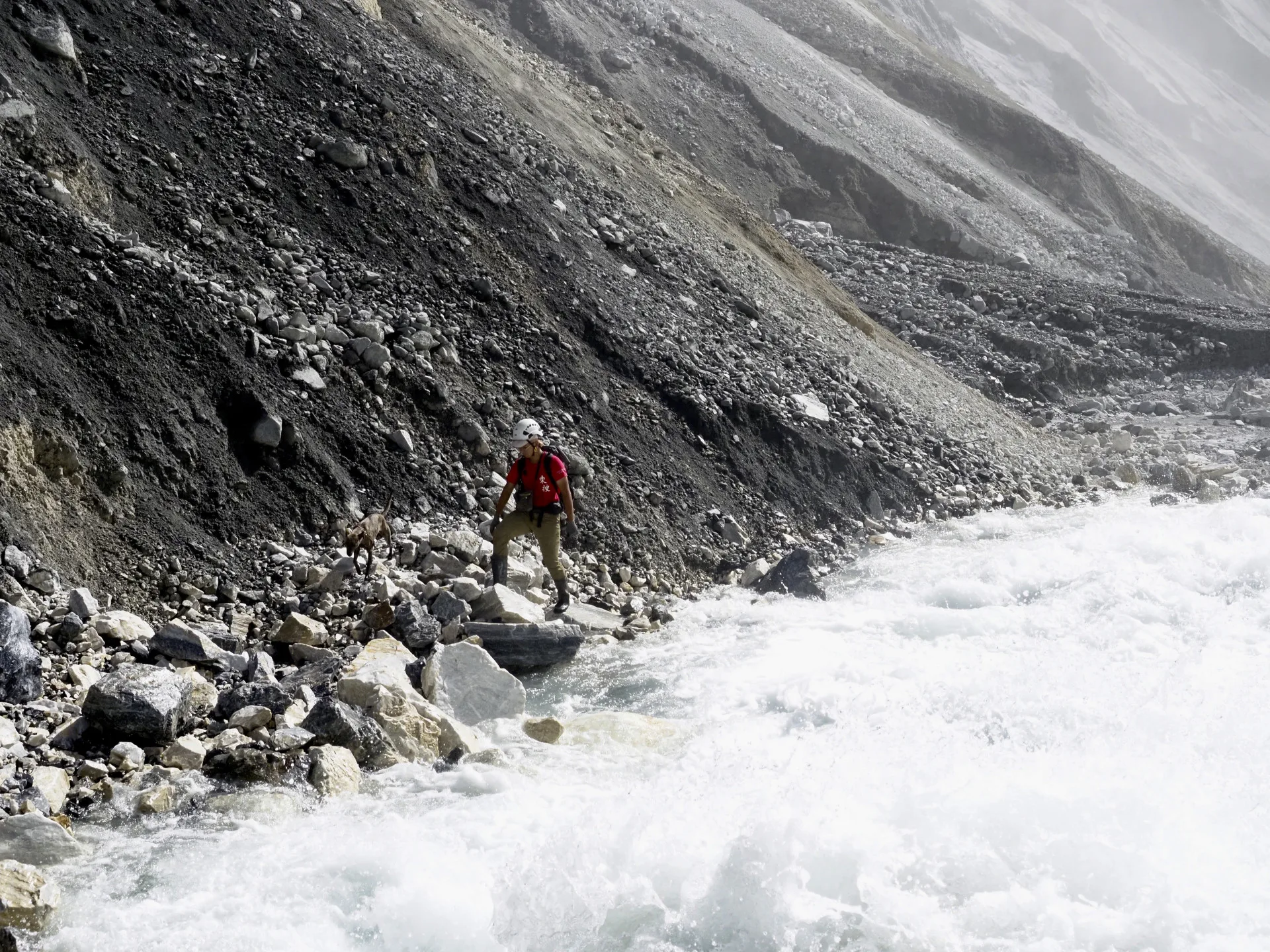 馬太鞍溪主流溢流口之下水勢甚大,圖為嚮導協助以十字鎬挖鑿左岸崩塌地之臨時腳點。林保署花蓮分署提供