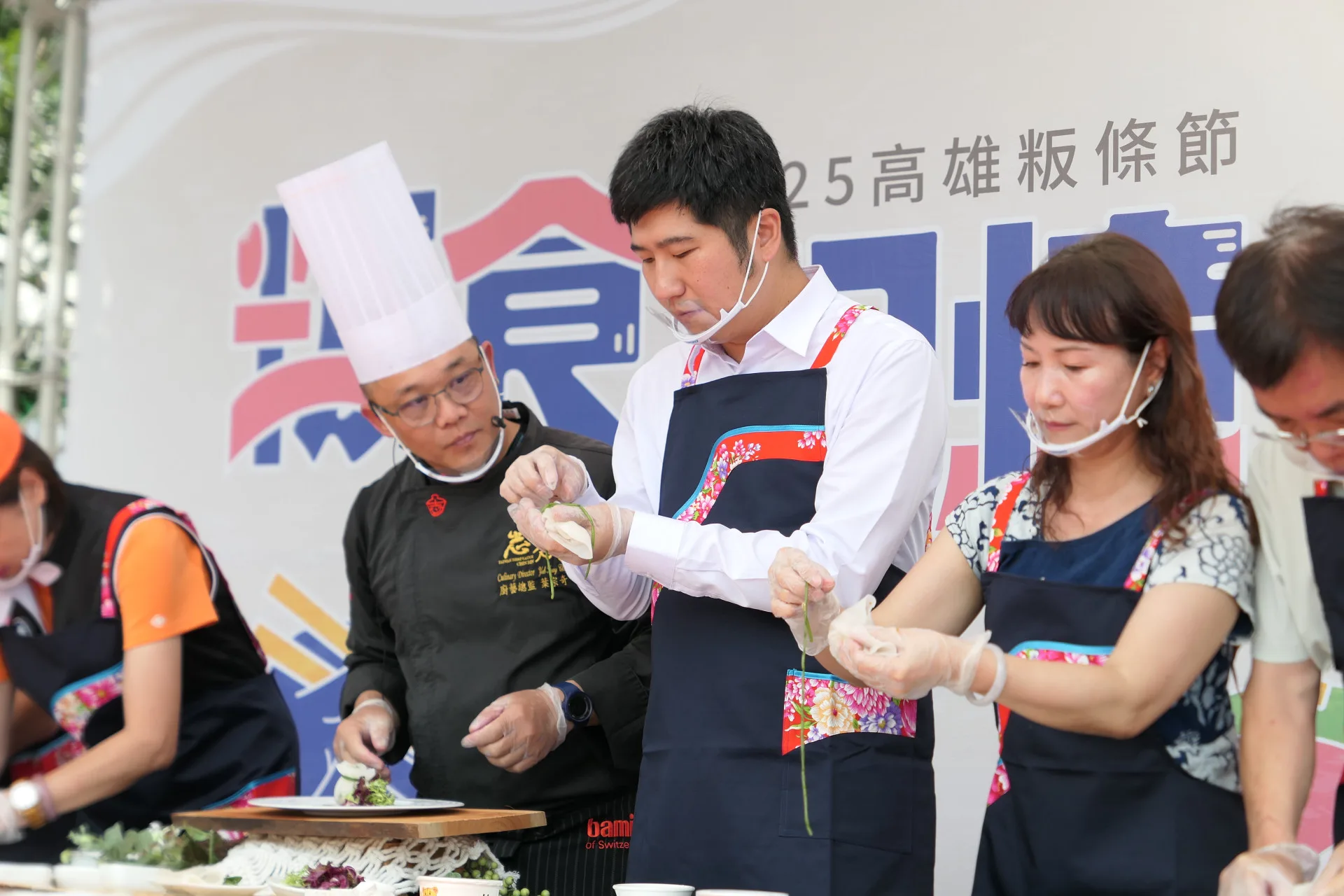 客委會副主委邱星崴與總舖師阿奇師一同製作創意料理「粄條石榴包」。客家委員會提供