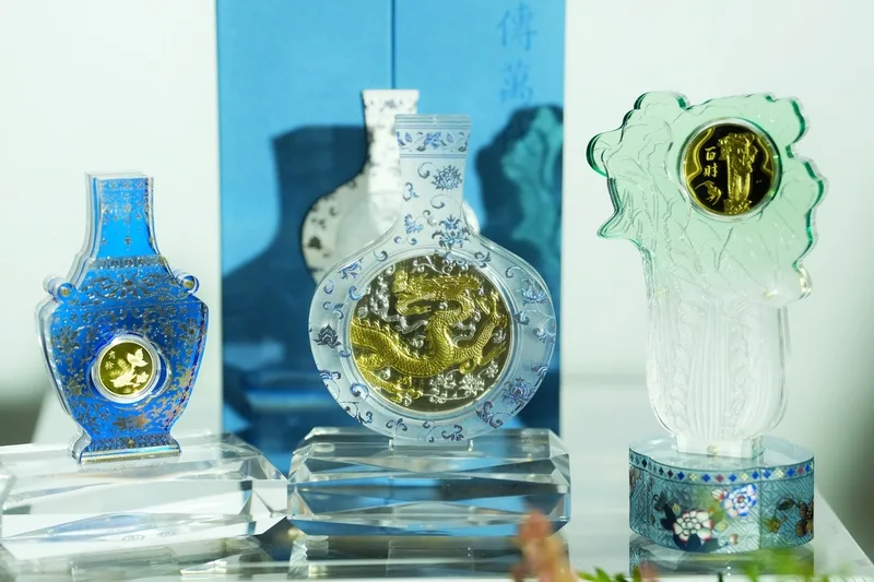國立故宮博物院成立百週年，台灣銀行14日推出限量「故宮百年紀念金銀條塊」共3款，包括以故宮人氣鎮館之寶「翠玉白菜」為主題的「福祿百財紀念金條」（右），與「連年有餘紀念金條」（左）、「龍傳萬代紀念銀條」（中）。中央社