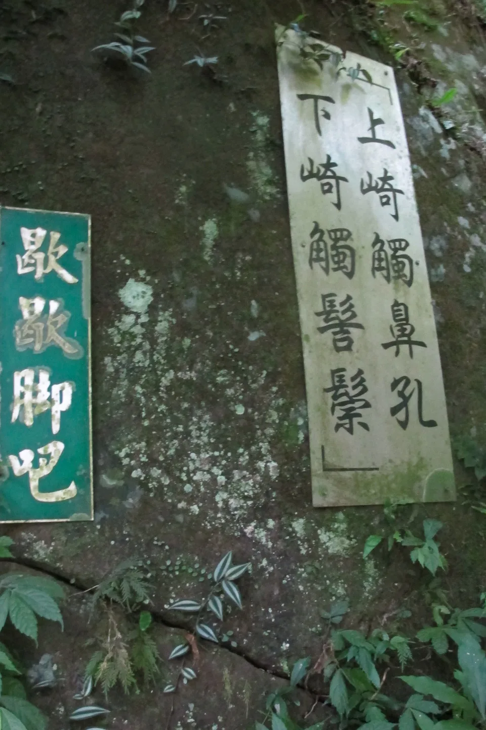 楔（錫）隘古道七十二段掛著「上崎觸鼻孔，下崎觸髻鬃」、「歇歇腳吧！」牌子。何來美攝