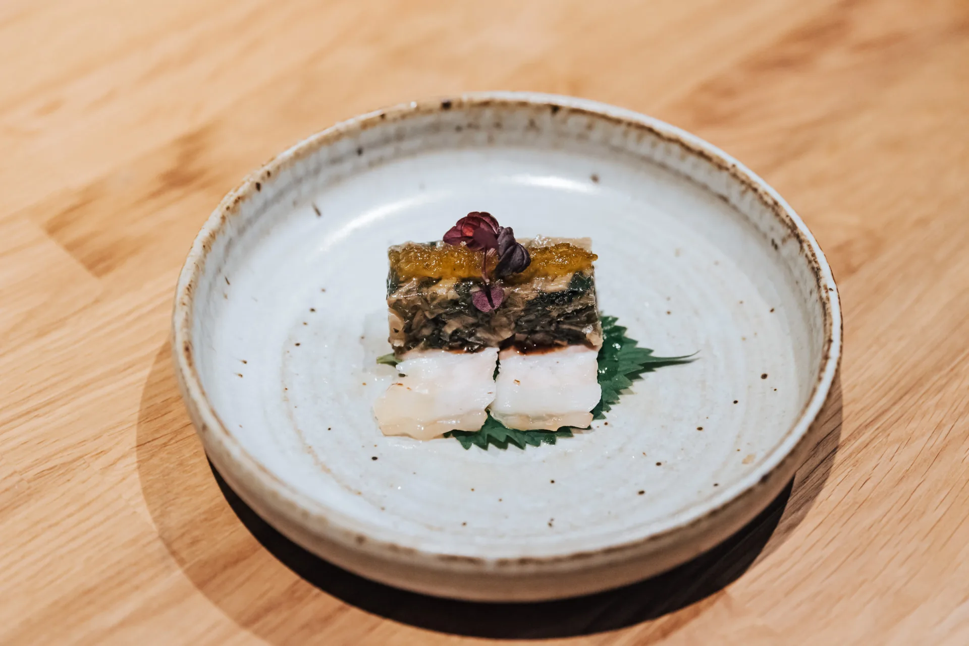 以巴薩米克醋桶進行發酵的覆菜，由米其林綠星餐廳 Embers 主廚郭庭研發菜品，取其酸鹹層次融入紅酒豬尾肉凍，展現出可與酒對話的發酵風味。台灣美食技術交流協會提供