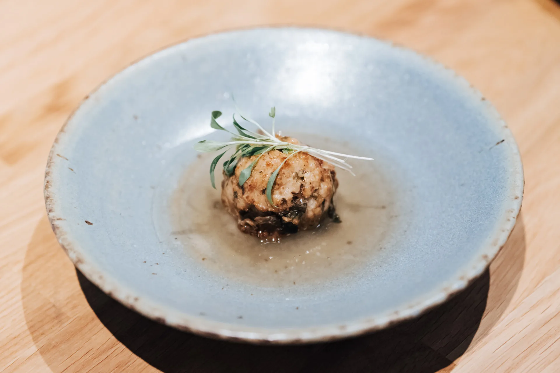 The One 主廚王孟澤以苗栗公館「福菜」及三灣品牌「金椿茶油工坊」為基底油脂，重新演繹傳統肉片湯。台灣美食技術交流協會提供