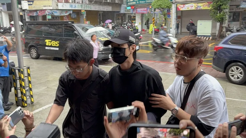 藝人閃兵案延燒,新北檢警展開第三波搜索,永和警分局21日上午將棒棒糖藝人小杰(中)拘提到案說明。中央社