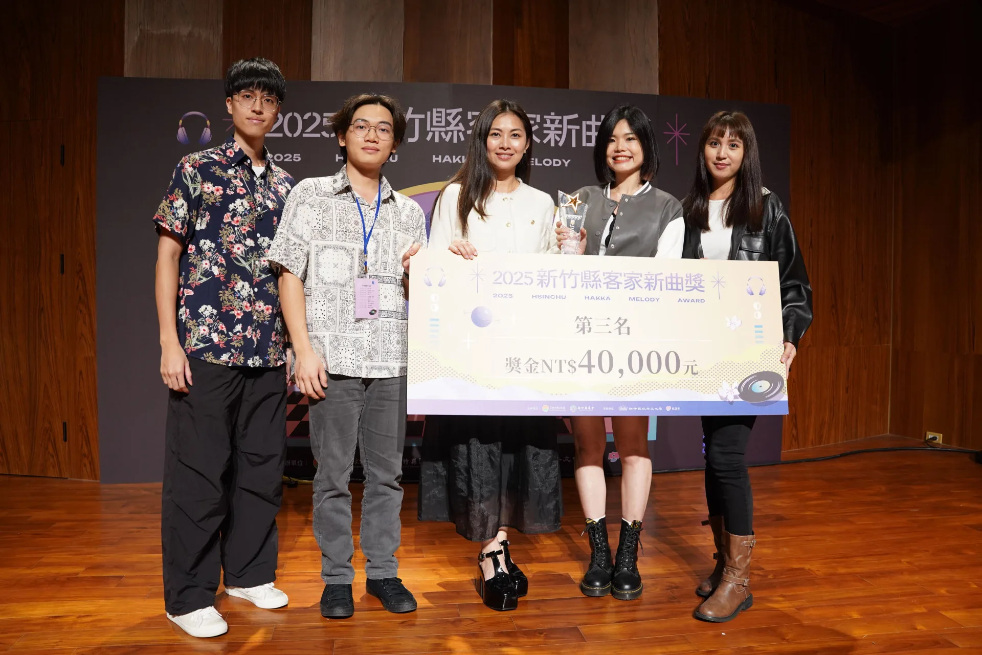 「2025新竹縣客家新曲獎」第三名則由劉美伶作詞作曲的〈客語Upload〉獲得，獲頒獎盃1座及獎金4萬元。