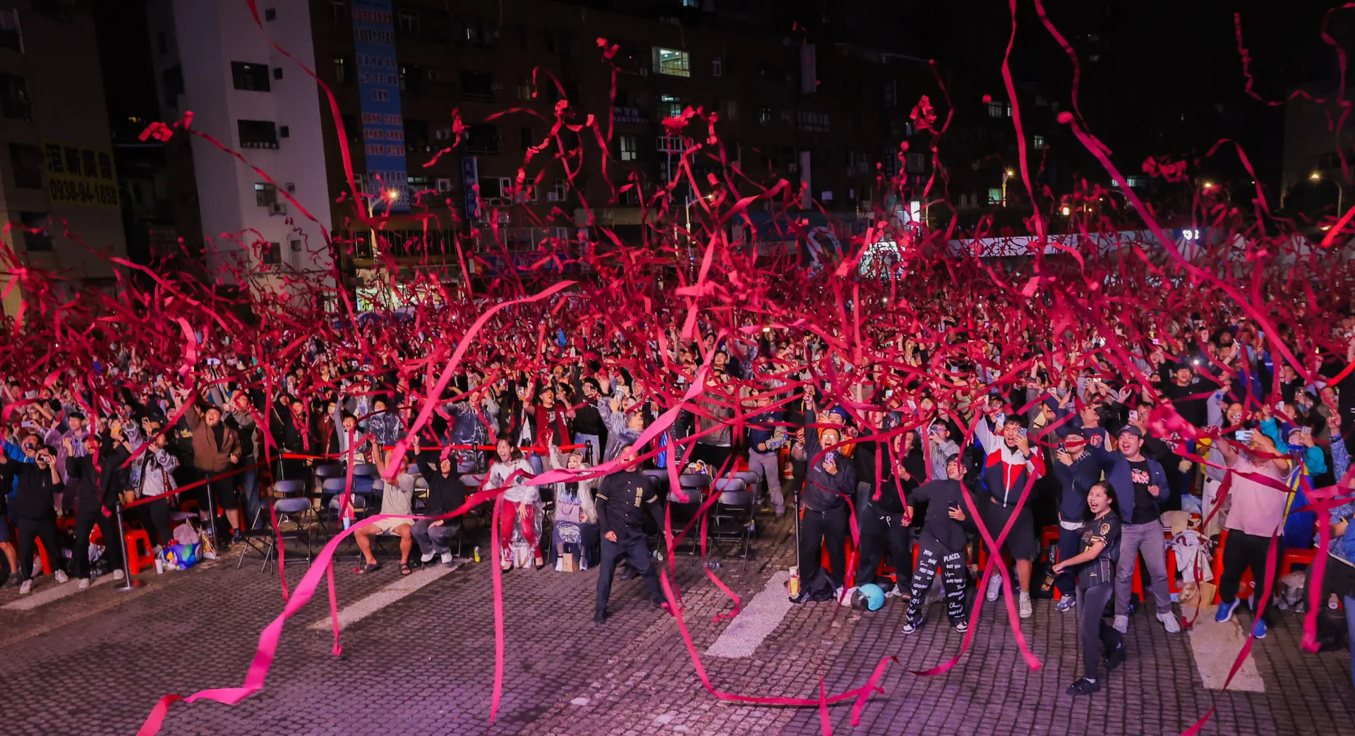 樂天桃猿27日榮獲「2025中華職棒台灣大賽總冠軍」,在桃市府前觀看直播球迷開心拋紅絲帶。桃市府提供