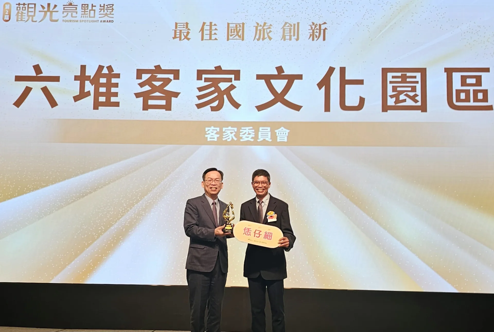 客發中心主任何金樑（右）上台受頒六堆客家文化園區「最佳國旅創新獎」。客委會提供