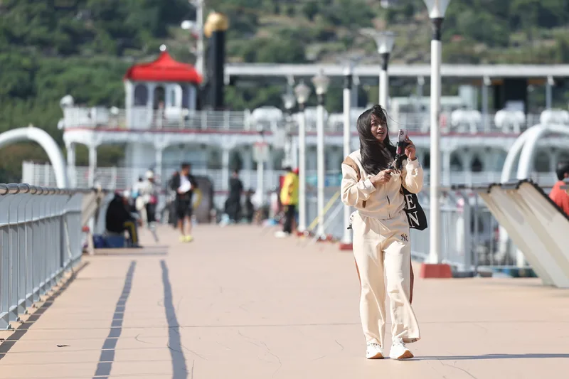 氣象署表示，17日東北季風增強、入秋首波最強冷空氣南下，17日午後氣溫將一路下降。圖為民眾16日在關渡碼頭散步。中央社
