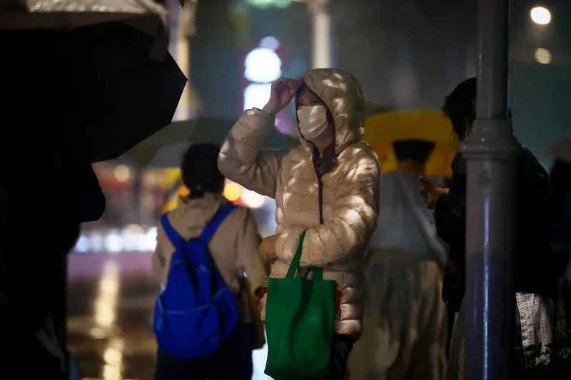 受東北季風影響,新北市板橋區17日午後轉為有雨的天氣,入夜氣溫降低,街頭民眾穿上羽絨外套禦寒。中央社