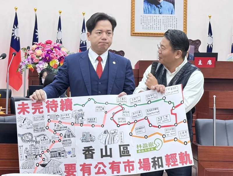新竹市議員林盈徹（右）20日在議會總質詢時，將手繪的「香山版」輕軌地圖贈予代理市長邱臣遠（左），盼市府能將新竹輕軌延伸至香山區。中央社