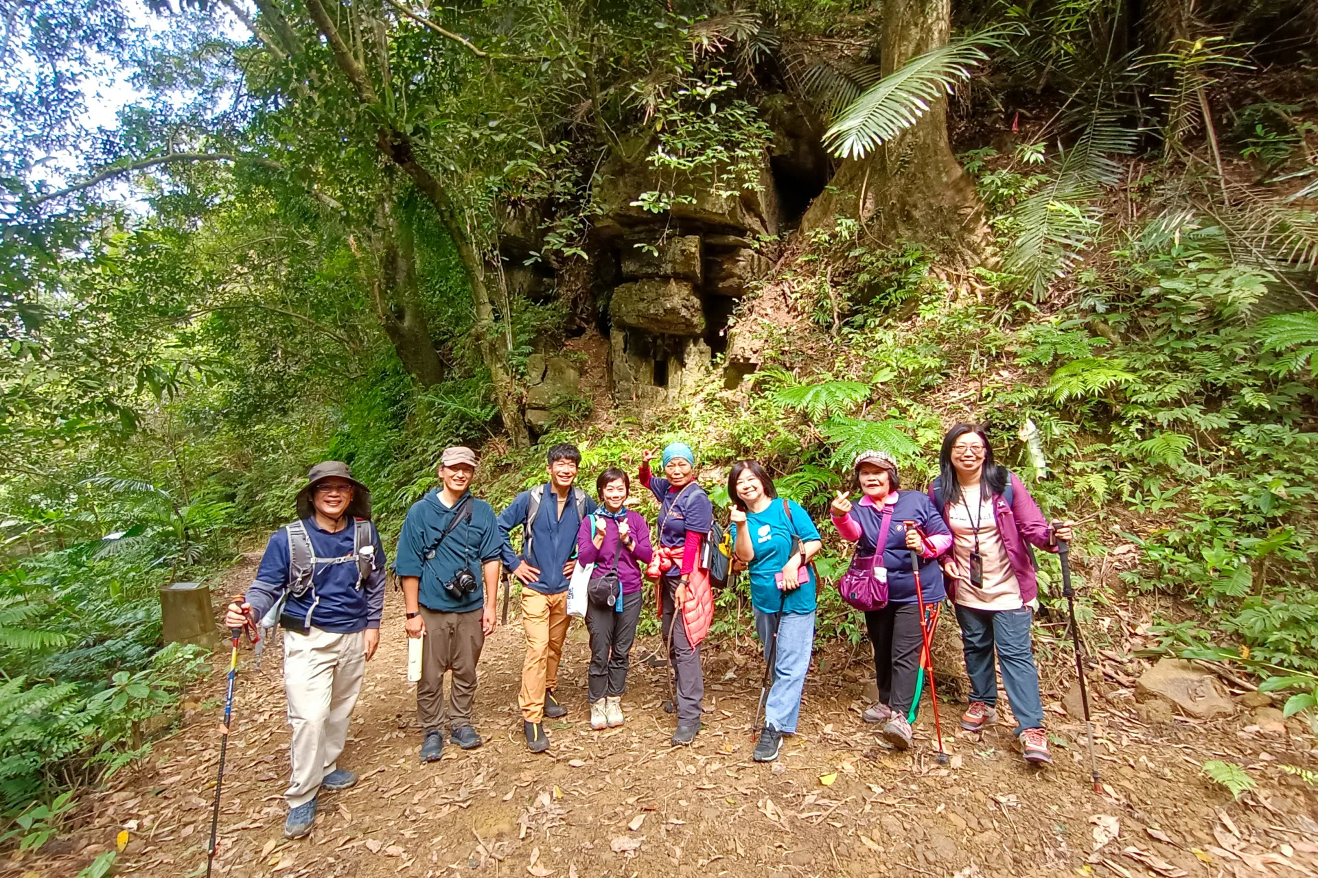 龍潭工作站導覽員進行現地的歷史生態導覽，日本夥伴對於小粗坑古道的文化很有興趣，特別於山神伯公原址前合影。台灣千里步道協會提供