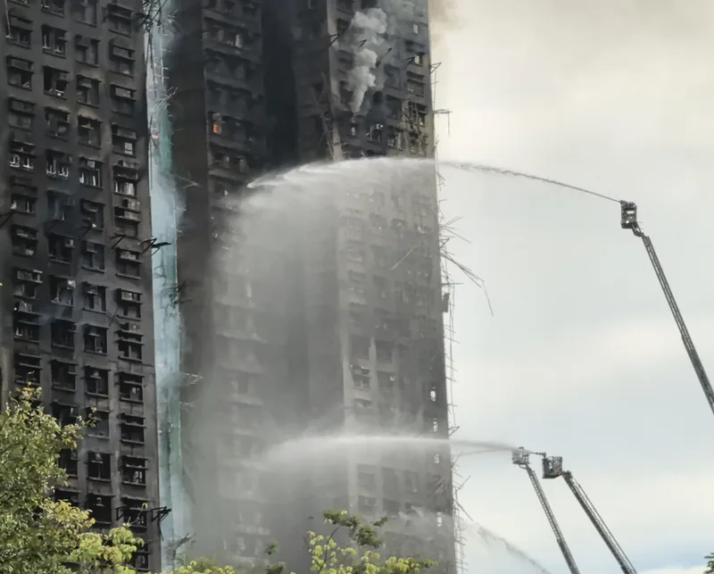 香港大埔宏福苑大火,自26日下午焚燒至今,圖為27日早上10時,消防員向大樓射水。中央社