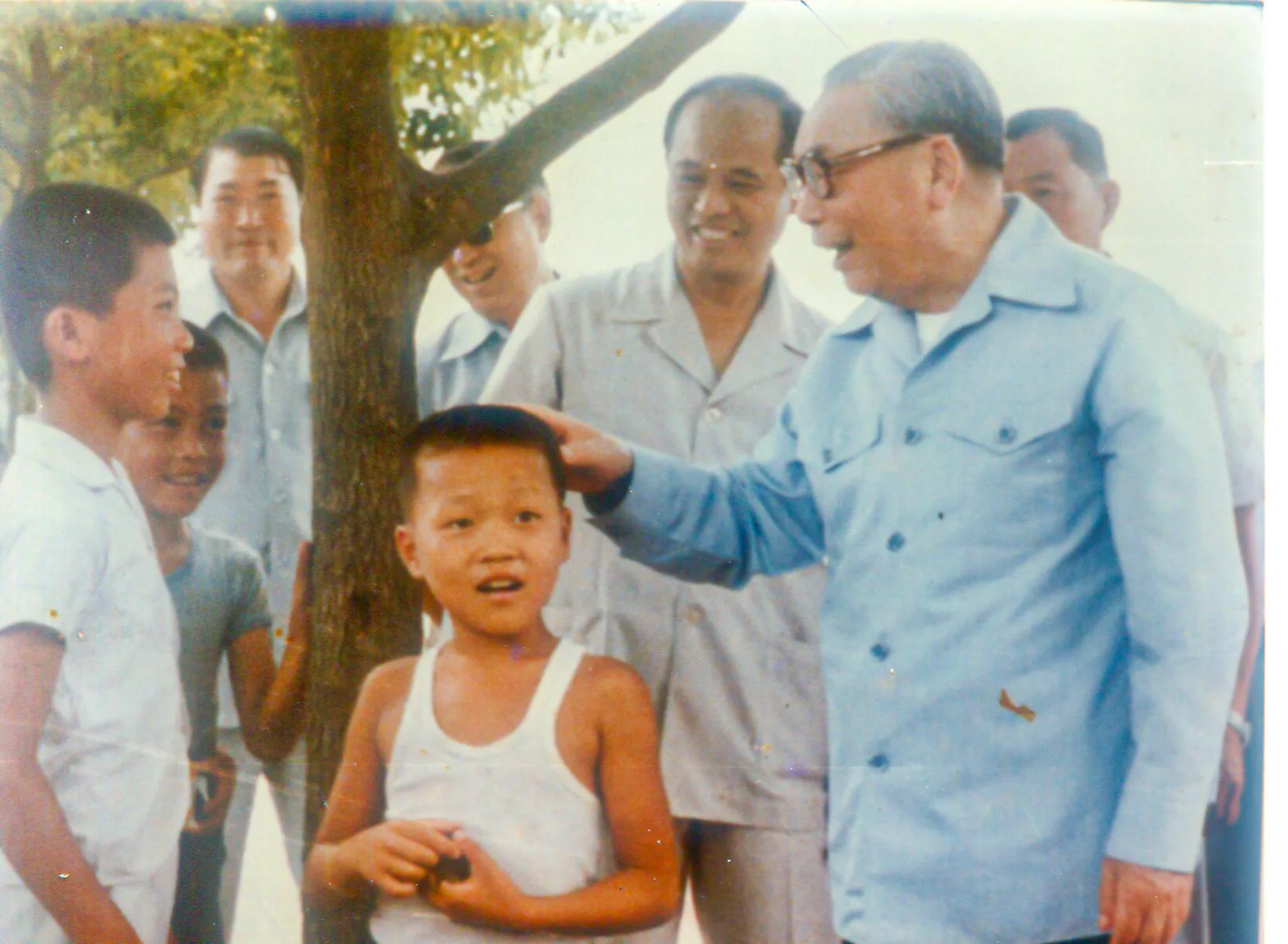 蔣經國擔任行政院長、總統期間常下鄉，他簡樸、親民形象，深植人心。圖為他到苗栗縣明德水庫參觀遇到一群小朋友，親切寒暄，站在他左側的是當時苗栗縣政府主任秘書周振章。何來美攝