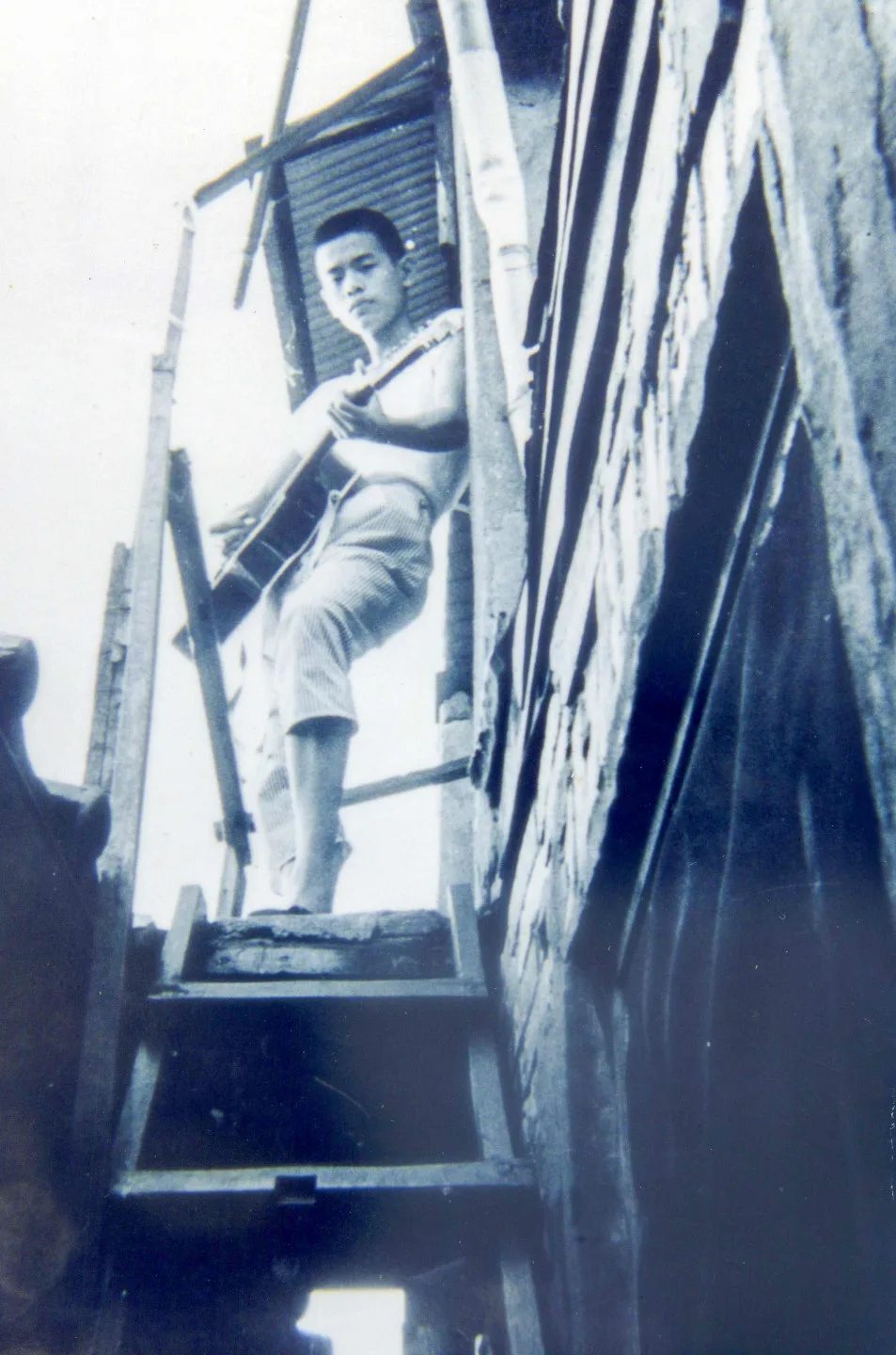 林子淵年輕時就玩吉他,在台北市信義路三段的房子前留影。楊國鑫提供