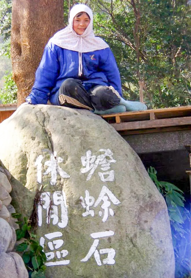 新竹縣最年輕一位童養媳甘美雲,獨坐橫山鄉油羅溪畔看著溪中的蟾蜍石。陳權欣攝