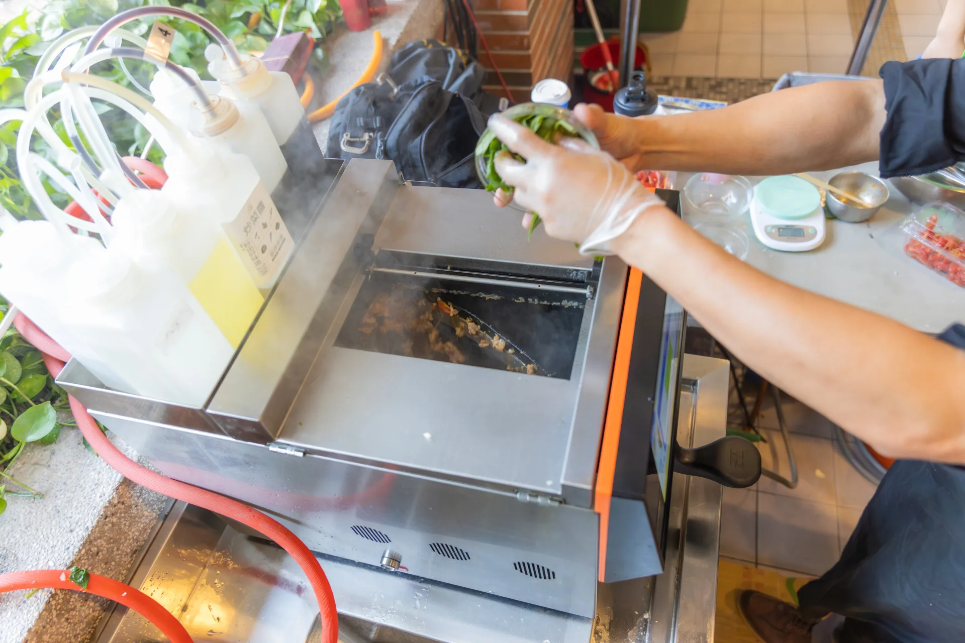 由人工依照AI指令備料，並倒進智能炒菜機中烹調。弘光科大餐旅管理系提供