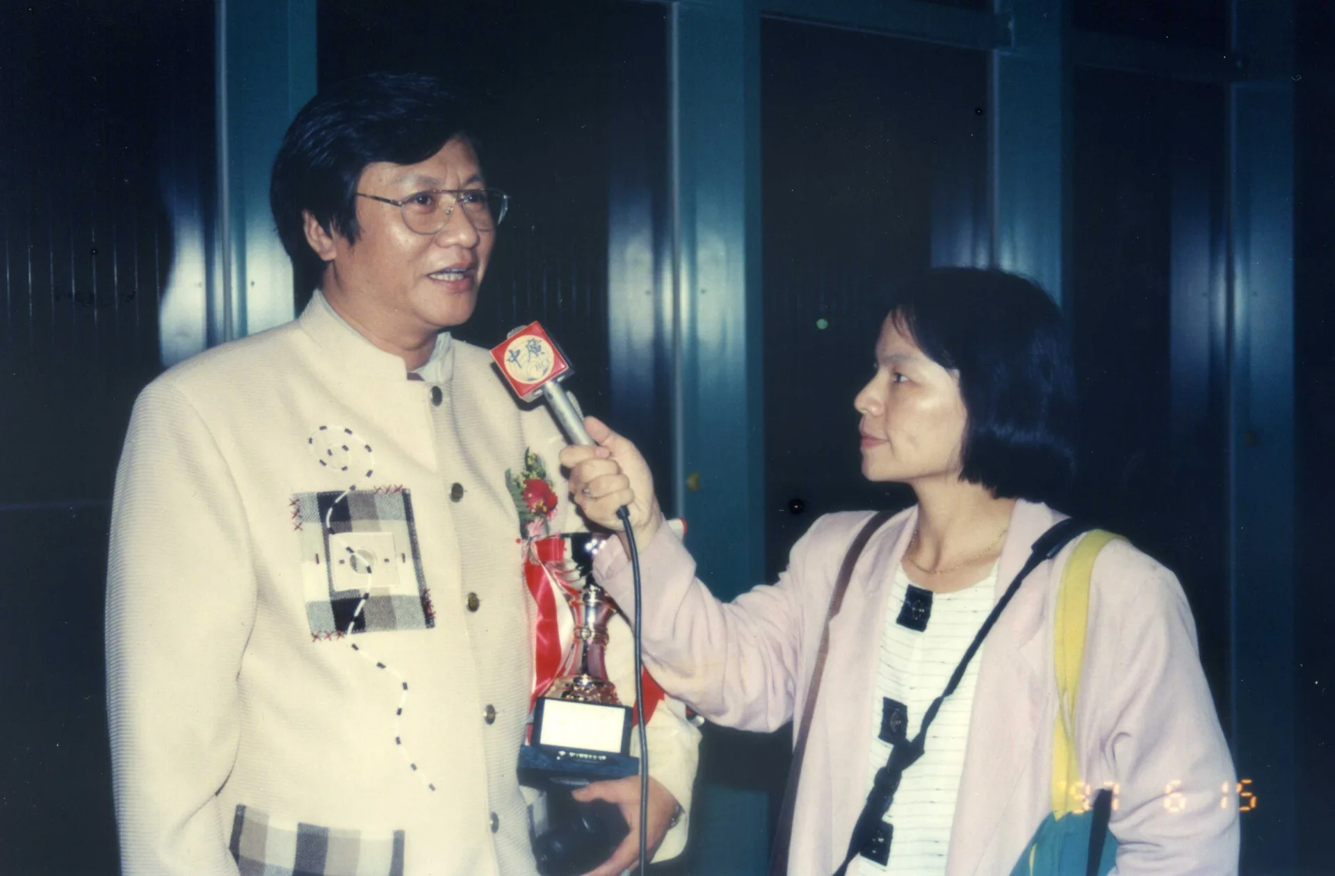 涂敏恆不少的歌曲是由林展逸（左）所唱紅的，包括：〈客家本色〉、〈死河灞〉、〈本本係英雄〉，這一張照片是新竹縣文化中心所辦理的第一屆客家新曲獎的頒獎典禮後，林展逸接受中廣記者黃玉美（右）專訪，當時的縣長是范振宗，我是這個獎項的籌備委員，參與推動客家流行歌。1997，竹北，楊國鑫攝