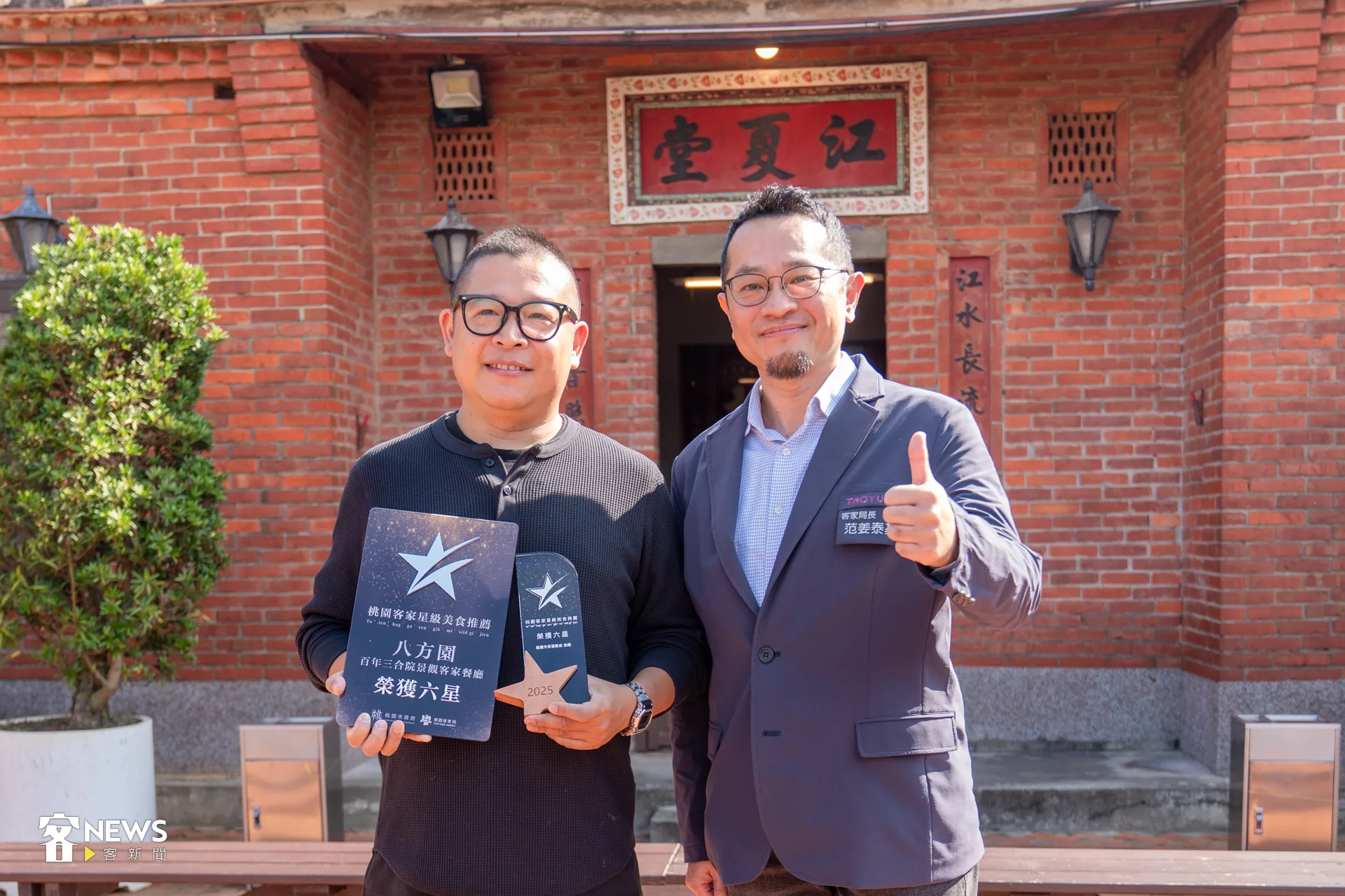 桃園市客家局長范姜泰基（右）頒發六星獎牌給八方園餐廳老闆黃帥欽（左）。李宥妍攝
