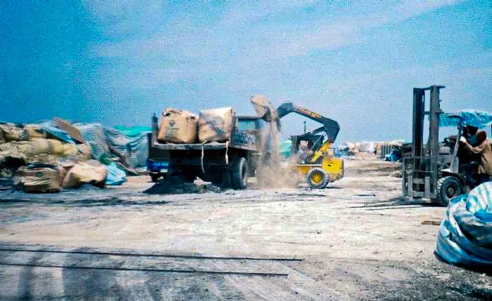 新竹市焚化爐當年在清運灰渣時，現場工人幾乎沒有任何防護措施。推土機高舉、翻動灰渣，破損的太空包讓粉塵直接灑落，現場灰塵瀰漫。陳權欣攝