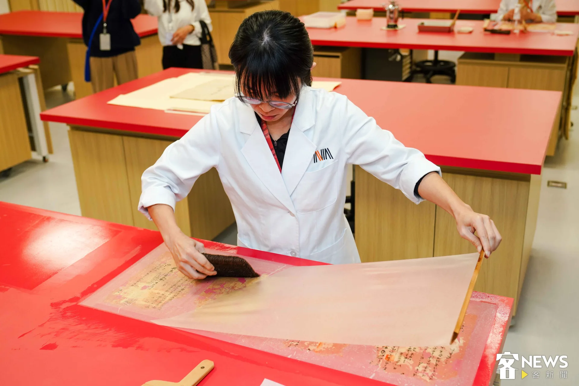 紙質檔案修護時，人員會以館內自製的稀漿糊，覆上楮皮紙進行補強，稱為「小托」。朱愷元攝。朱愷元攝