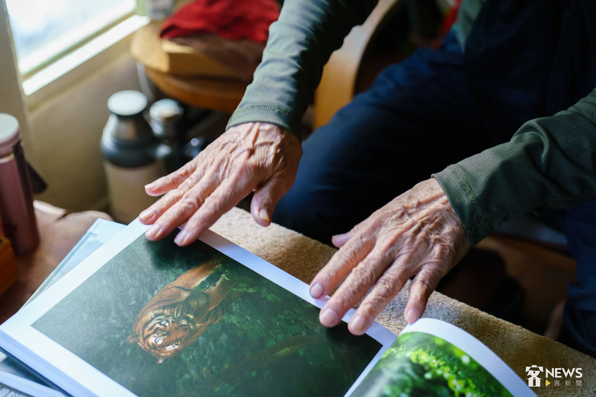 徐仁修翻著即將出版的《透視熱帶雨林》攝影集，他認為「貓科動物」是拍起來最有趣的動物之一。李台源攝