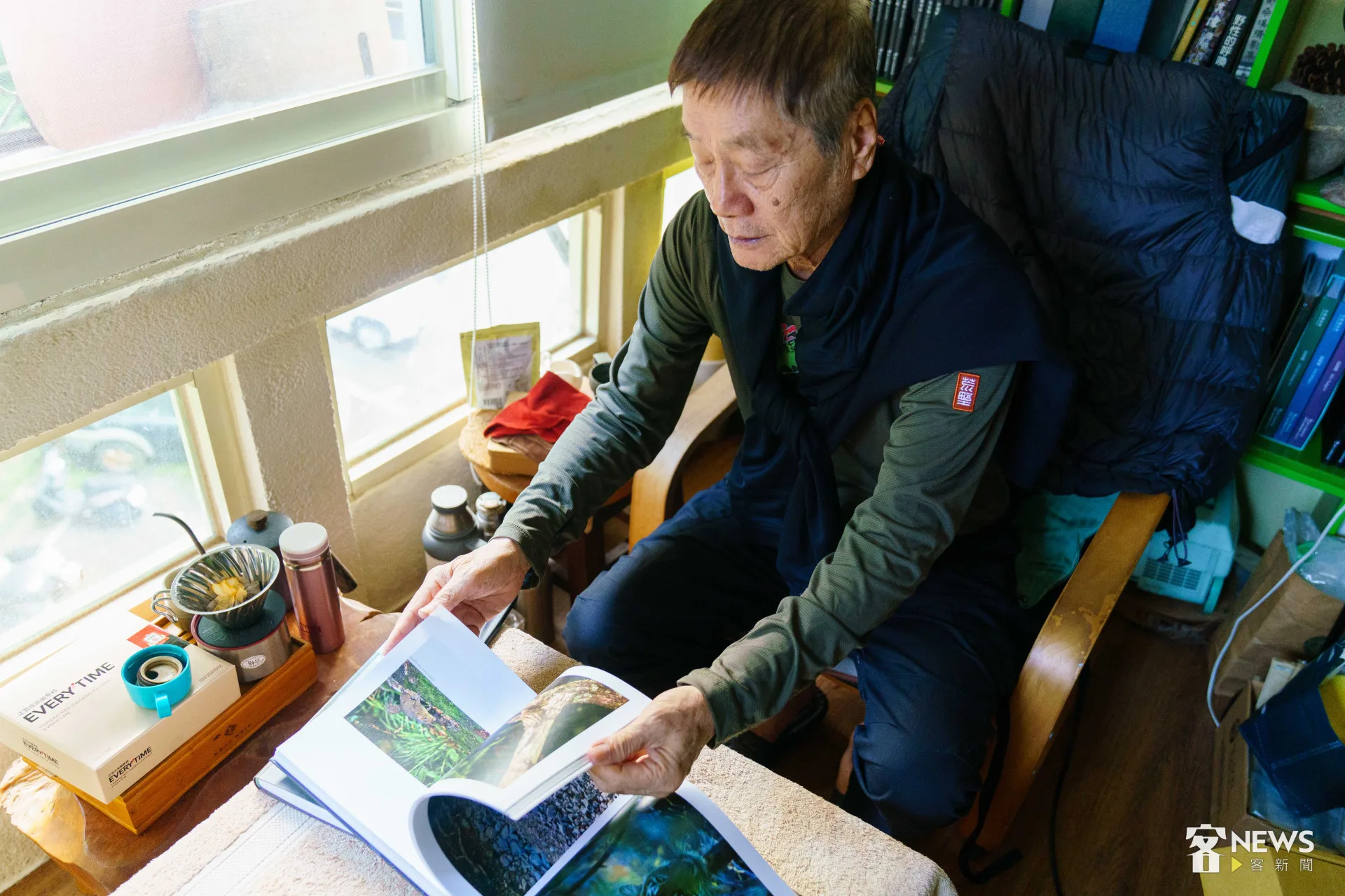 徐仁修翻著即將出版的《透視熱帶雨林》攝影集。李台源攝