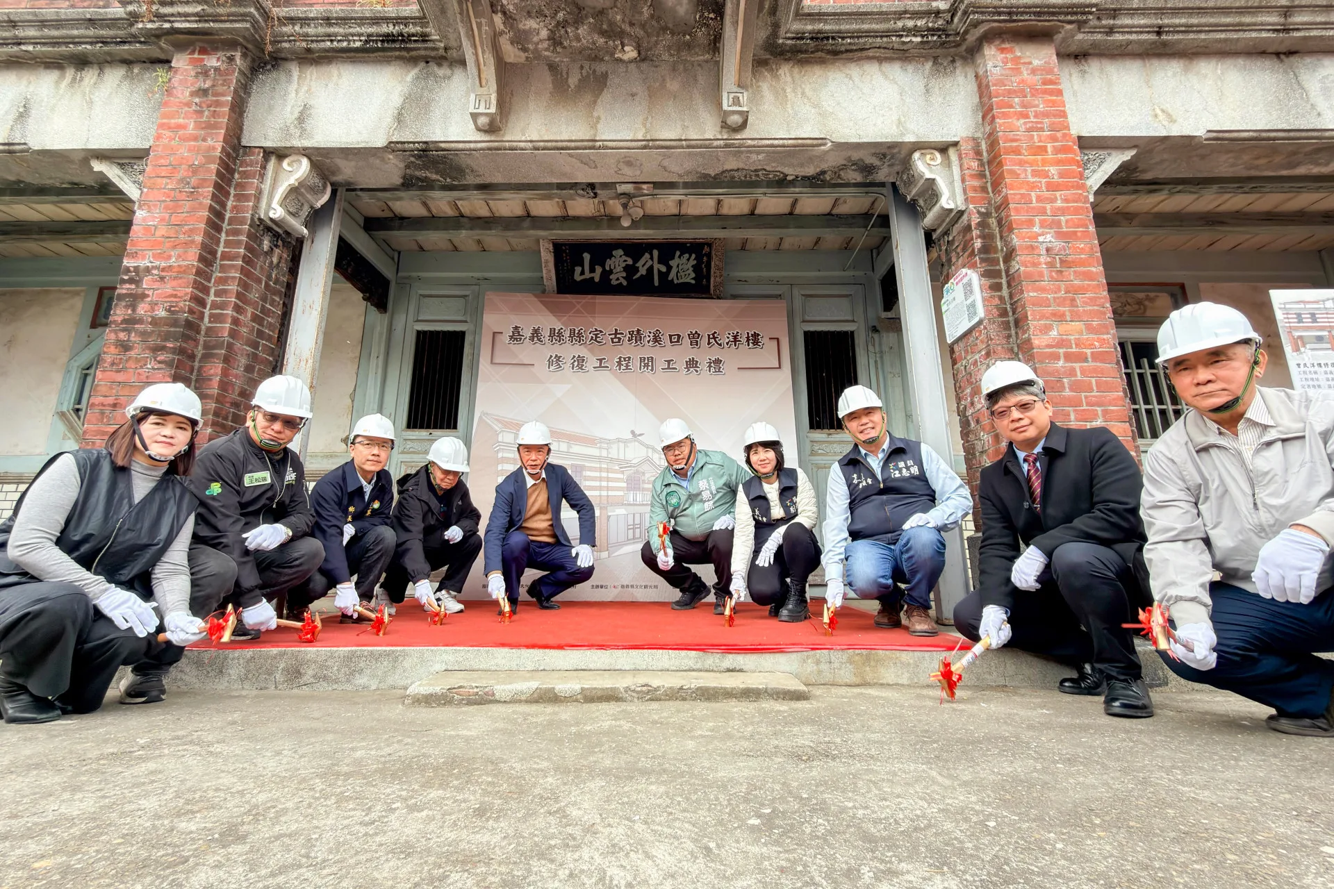 溪口曾家洋樓修復開工典禮,眾人手持金槌敲擊,象徵工程啟動。嘉義縣政府提供