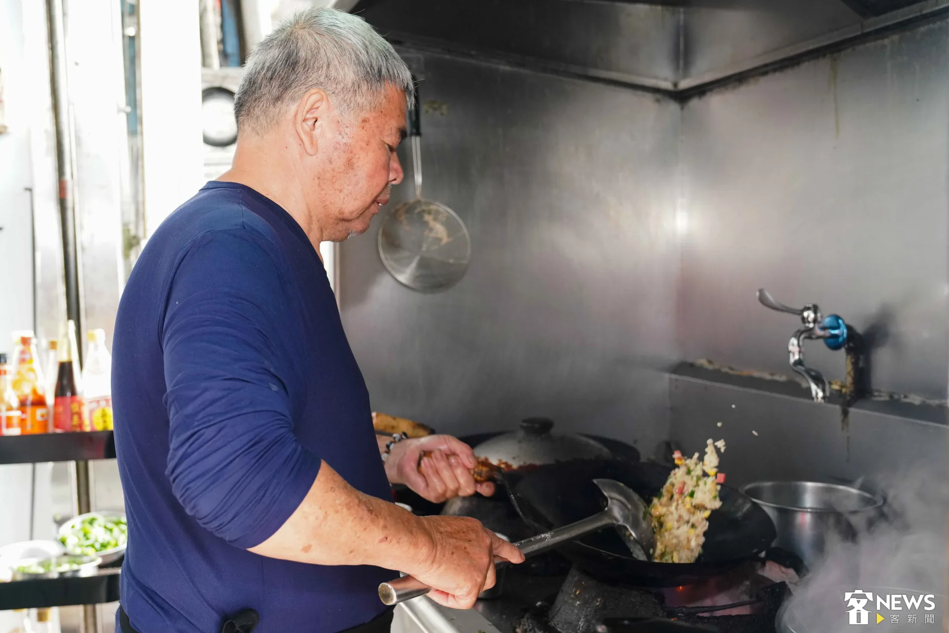從年輕做到退休年紀的董于安父親熟練翻炒料理。朱愷元攝