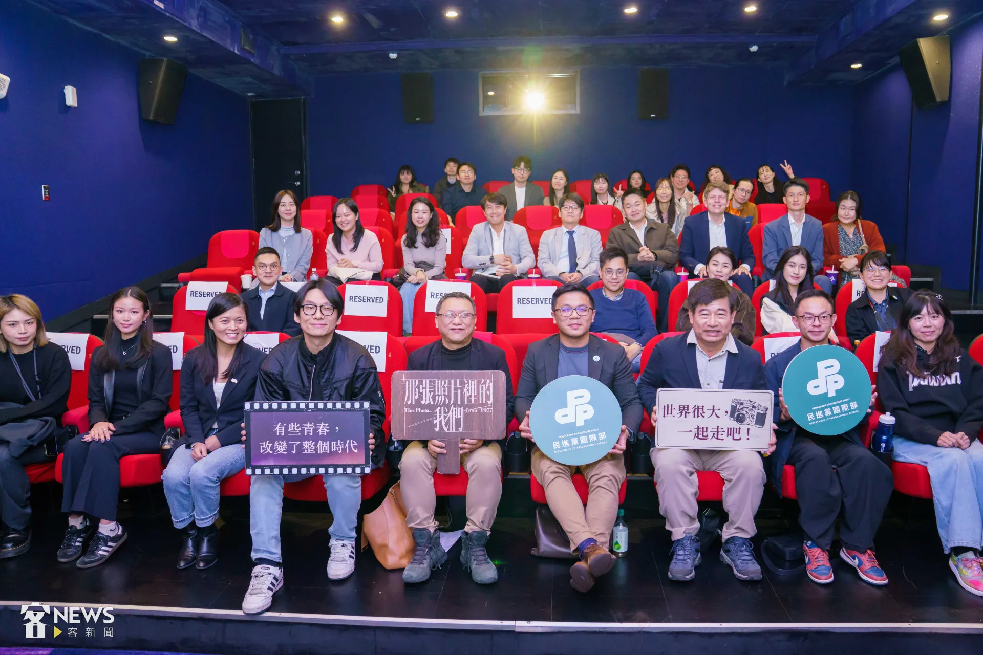 民進黨國際事務部、客家部包場電影《那張照片裡的我們》，前排為導演湯昇榮（右5）、鄭乃方（左4）、國際部主任陳文昊（右4）、副主任邱雯莉（左3）、客家部主任黃駿翔（右2）、客傳會董事長宋廷棟（右三）合影。李台源攝