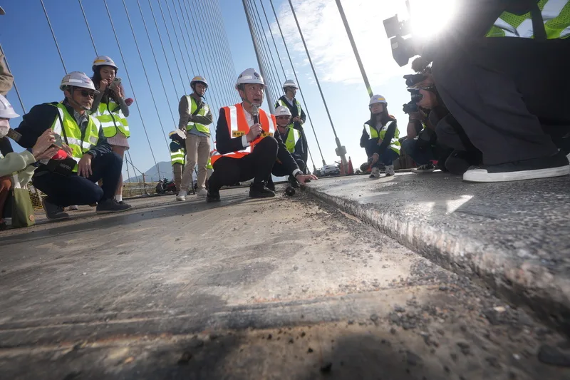 淡江大橋持續趕工中，交通部長陳世凱15日視察最新施工進度，介紹高性能GUSS瀝青混凝土是專為鋼橋設計的高性能鋪面材料。中央社
