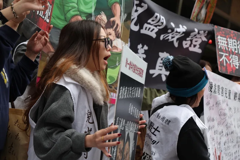 保母姐妹劉彩萱、劉若琳被控虐死剴剴案二審27日宣判,宣判前法院外民眾拿著手舉牌高喊口號表達訴求。中央社