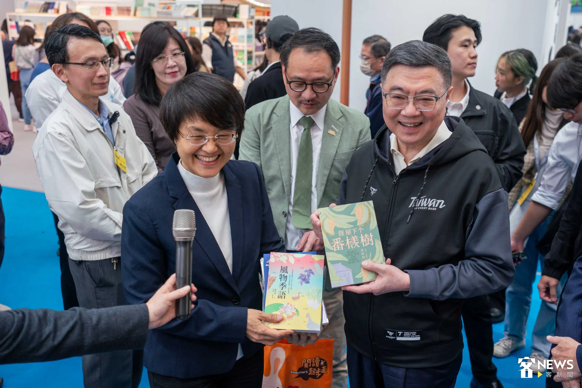 卓榮泰、古秀妃拿著《風物季語》及《𠊎屋下个番檨樹》合影留念。范修語攝