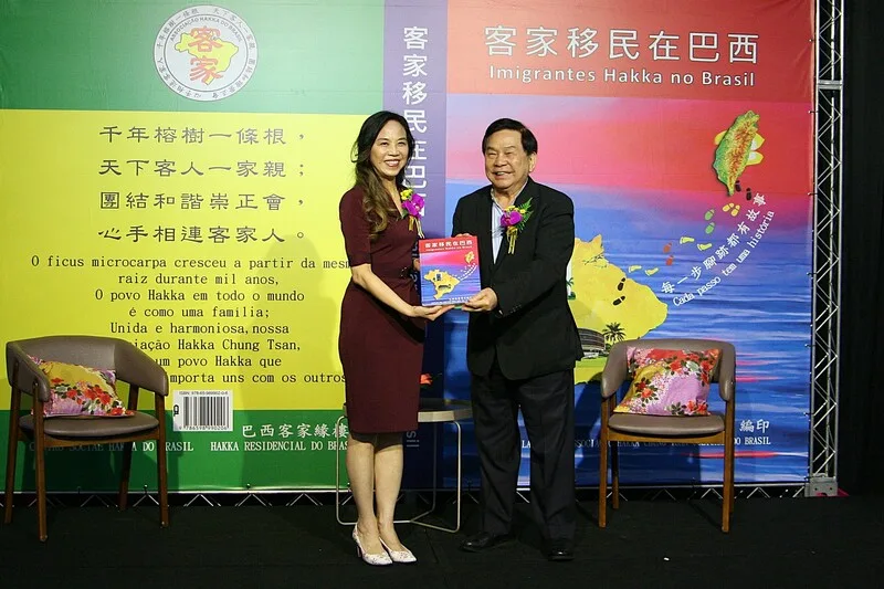 巴西僑界7日於聖保羅舉辦慶祝「客家移民在巴西」新書發行感恩茶會，發起人張永西（右）代表贈書予駐聖保羅台北經濟文化辦事處處長朱怡靜（左）。中央社