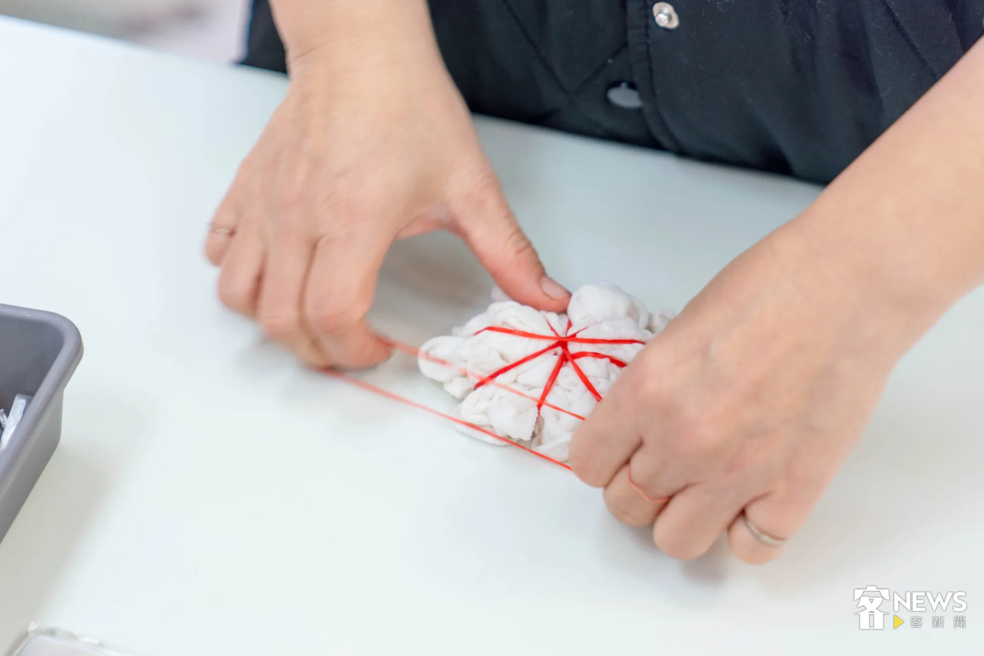 冷染體驗課上，柿染老師教學如何將布料綁出花紋。范修語攝