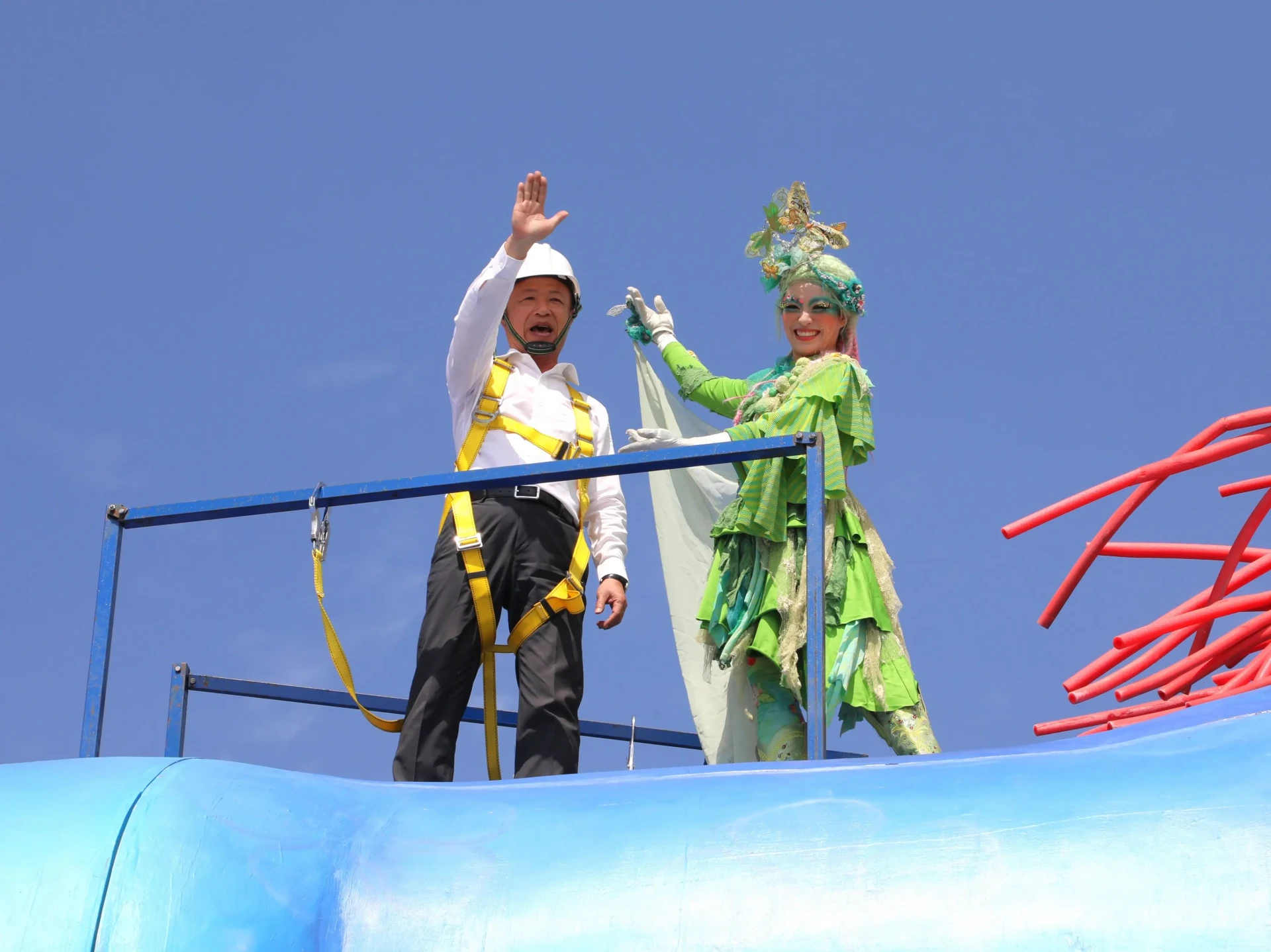 嘉義縣長翁章梁穿戴安全裝備攀登「雨馬」巨型裝置，呼喊大家要來看燈會。嘉縣府提供