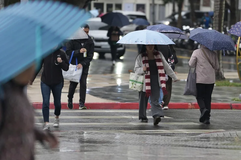 4日受華南雲雨區影響,各地都可能有短暫降雨,上半天降雨較明顯。民眾通勤時,撐傘在台北市北投區街頭穿梭。中央社