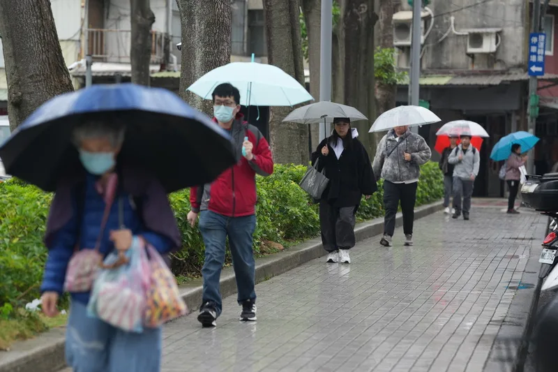 日受華南雲雨區影響,各地都可能有短暫降雨,上半天降雨較明顯。台北市北投區街道上,民眾紛紛撐傘避雨。中央社