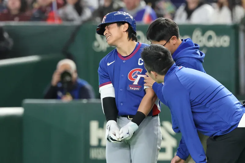 世界棒球經典賽（WBC）C組預賽5日在日本東京巨蛋開打，首戰由台灣隊迎戰澳洲隊。6局上台灣隊長陳傑憲（左）遭觸身球擊中手部，表情痛苦。中央社